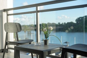 A balcony with two chairs, a table, and a potted plant.