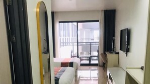 Une chambre d’hôtel avec un lit, un bureau, une télévision et une vue sur l’extérieur.