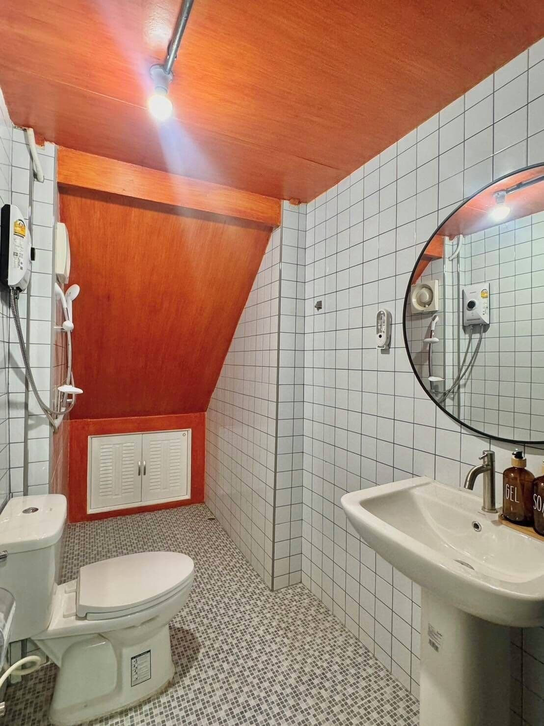 A bathroom with a toilet, sink, and shower.