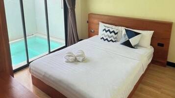 Een hotelkamer met een bed, een raam met uitzicht op een zwembad en een houten hoofdeinde.