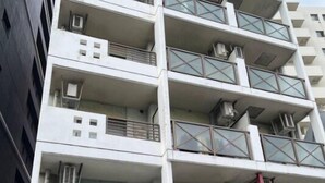 A multi-story building with balconies, air conditioning units, and a sign indicating a business center. - Fukuoka Loft 303 (Fukuoka)
