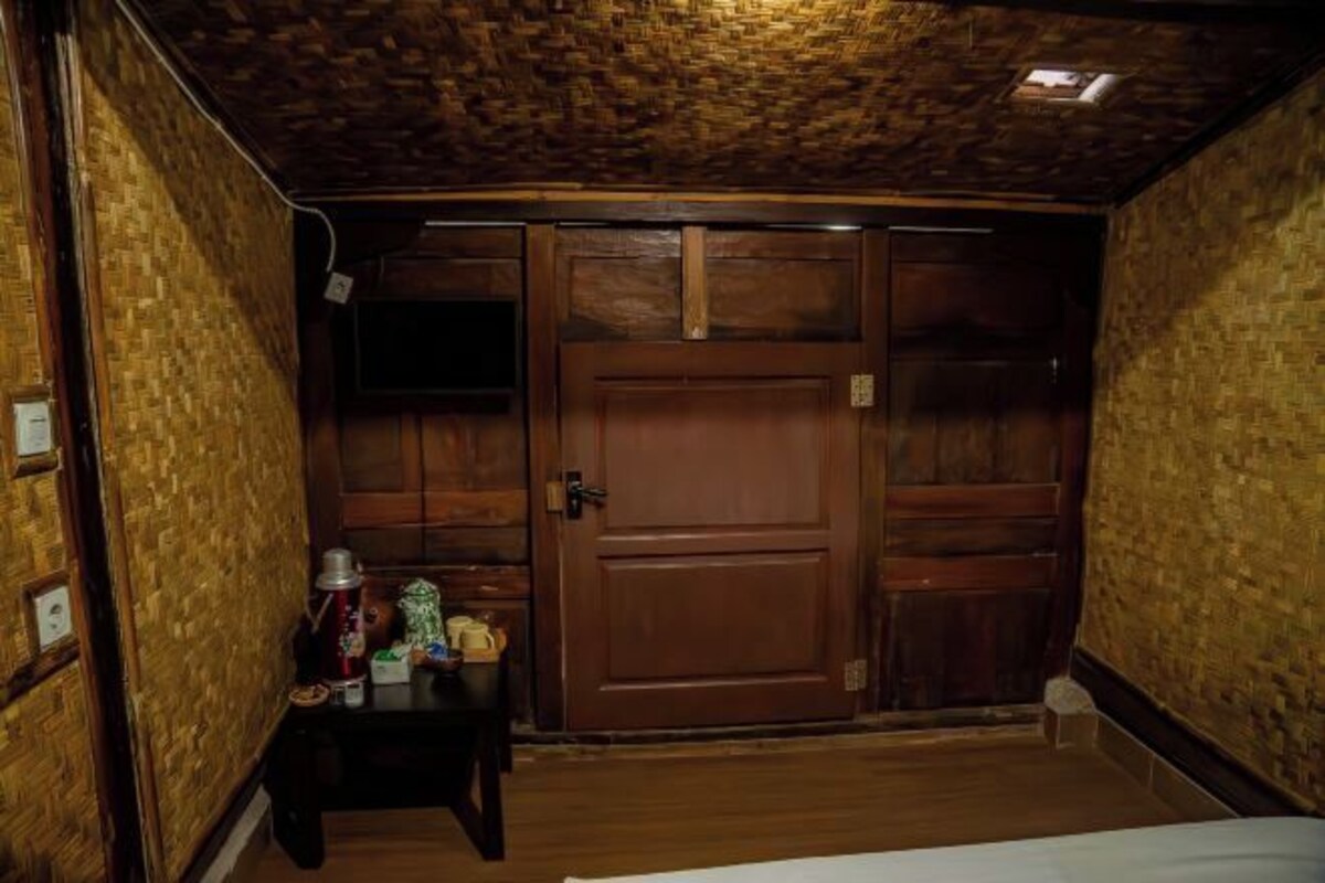 A room with a wooden door, a small table with items, and a brick-patterned wall.