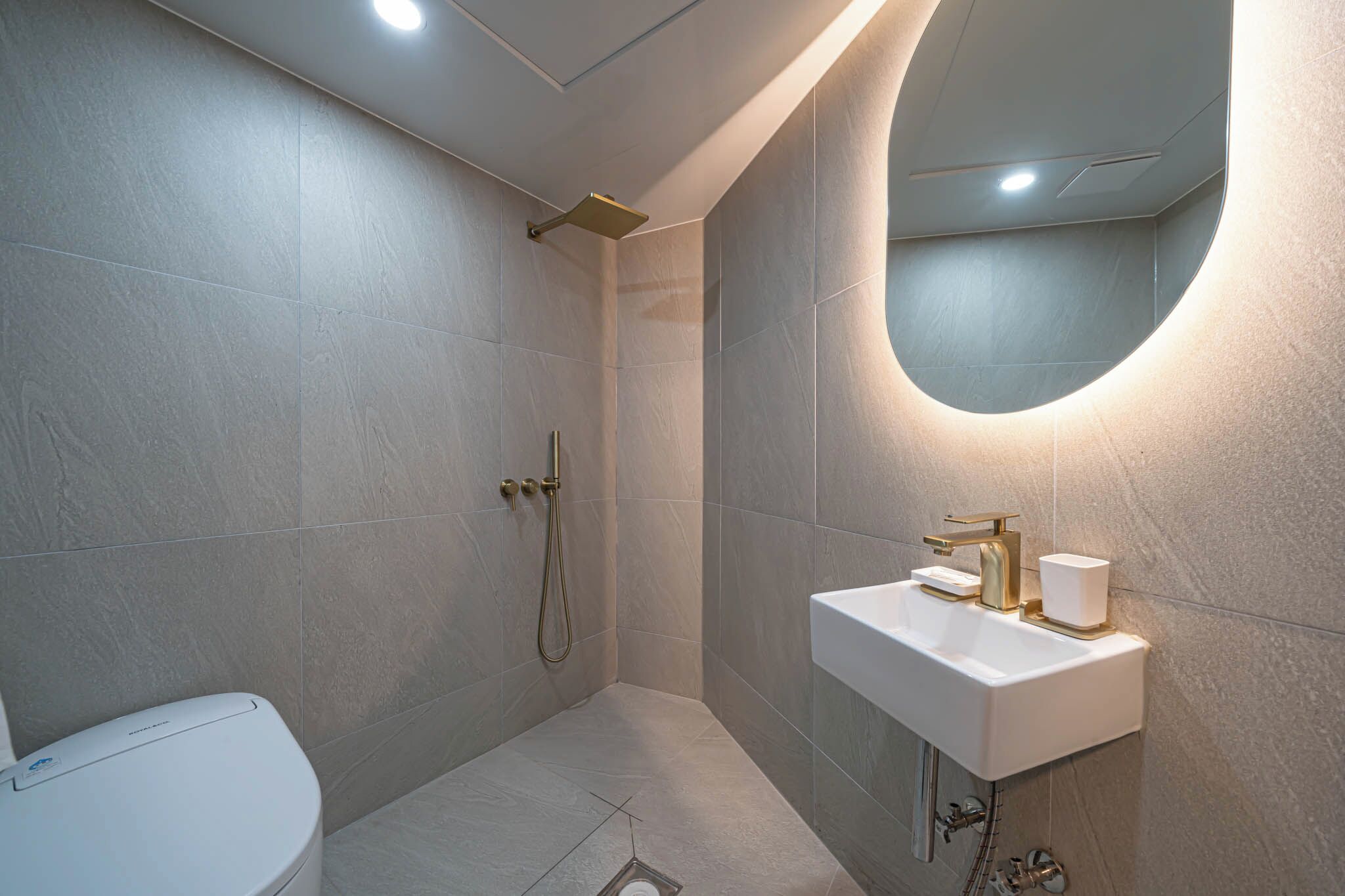 Une salle de bain moderne équipée d’une douche, de toilettes et d’un lavabo.