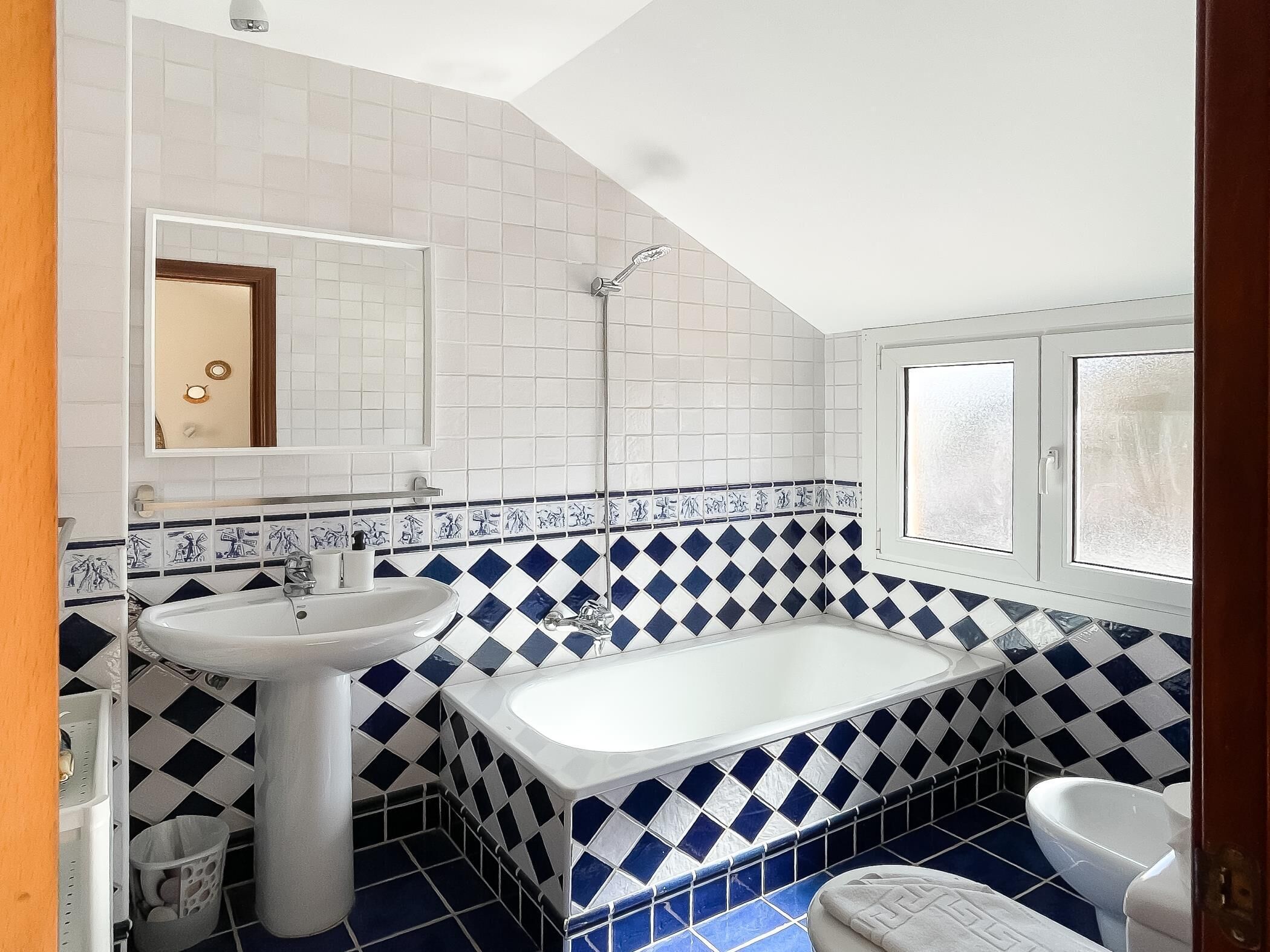A bathroom with a white sink, a bathtub, and a toilet.