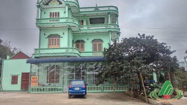 A multi-story building with a green facade, a blue car parked in front, and a signboard with text. - Viet Hoang Hostel Moc Chau - BAYLUXURY (Thao Nguyen)