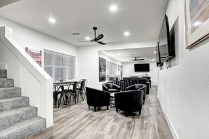 Een modern interieur met een trap, eethoek en zitplaatsen.