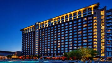 A multi-story hotel with a pool area in the foreground.