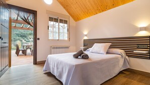 A bedroom with a wooden ceiling, a bed with white bedding, a radiator, and a window with blinds. - Amazing home in Algarinejo (Algarinejo)