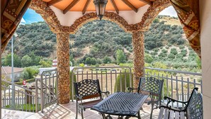 A covered outdoor seating area with a view of a hilly landscape. - Amazing home in Algarinejo (Algarinejo)