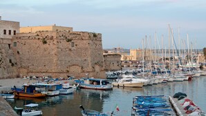 A harbor with boats docked near a historic stone wall. - Incoronata New Dependance by Interhome (Gallipoli)