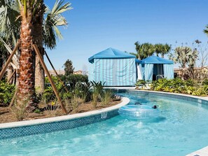A swimming pool with a 3 FT depth marker, surrounded by palm trees and blue tents.