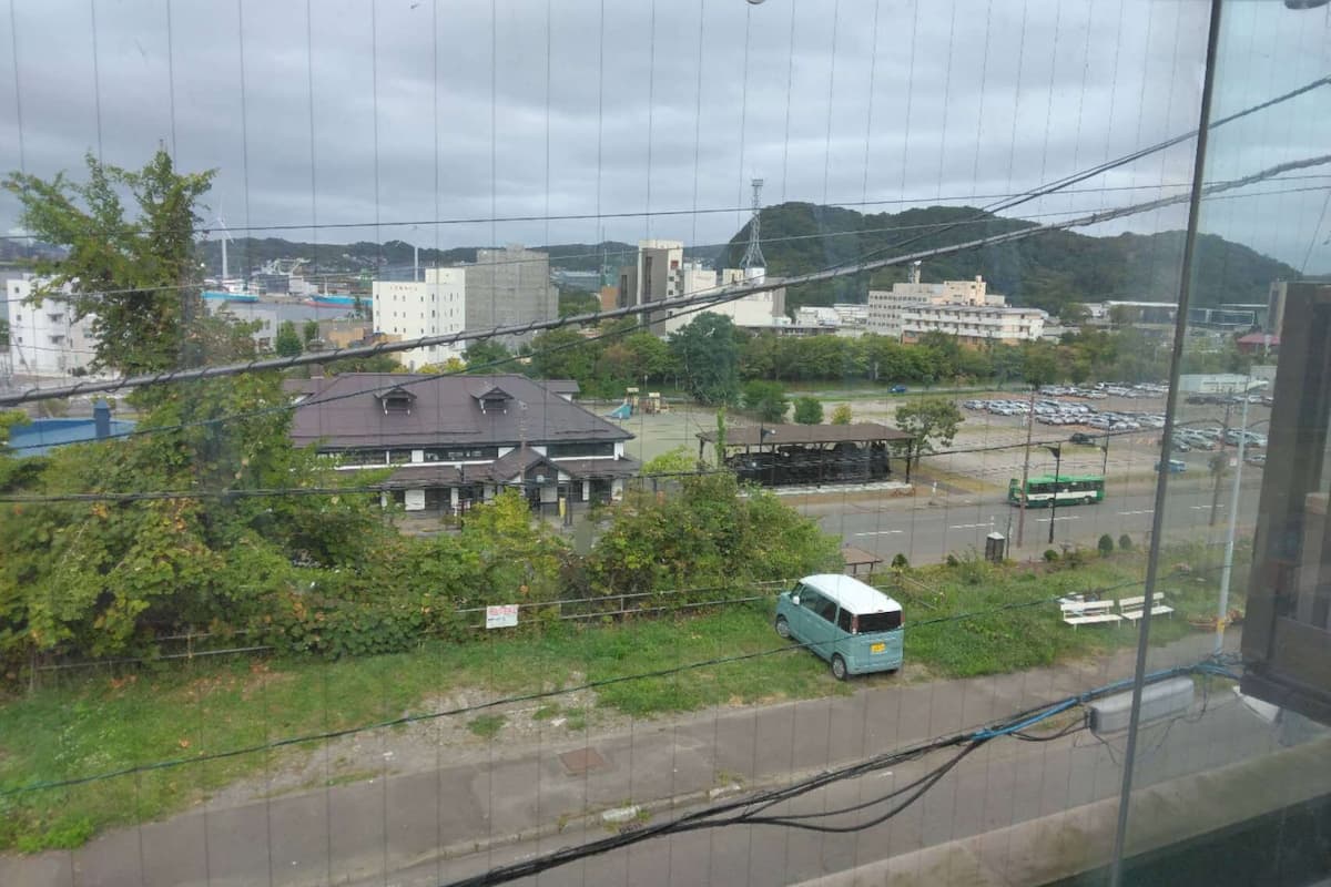 Une vue d’un bâtiment doté d’un toit plat, avec un parking au premier plan.