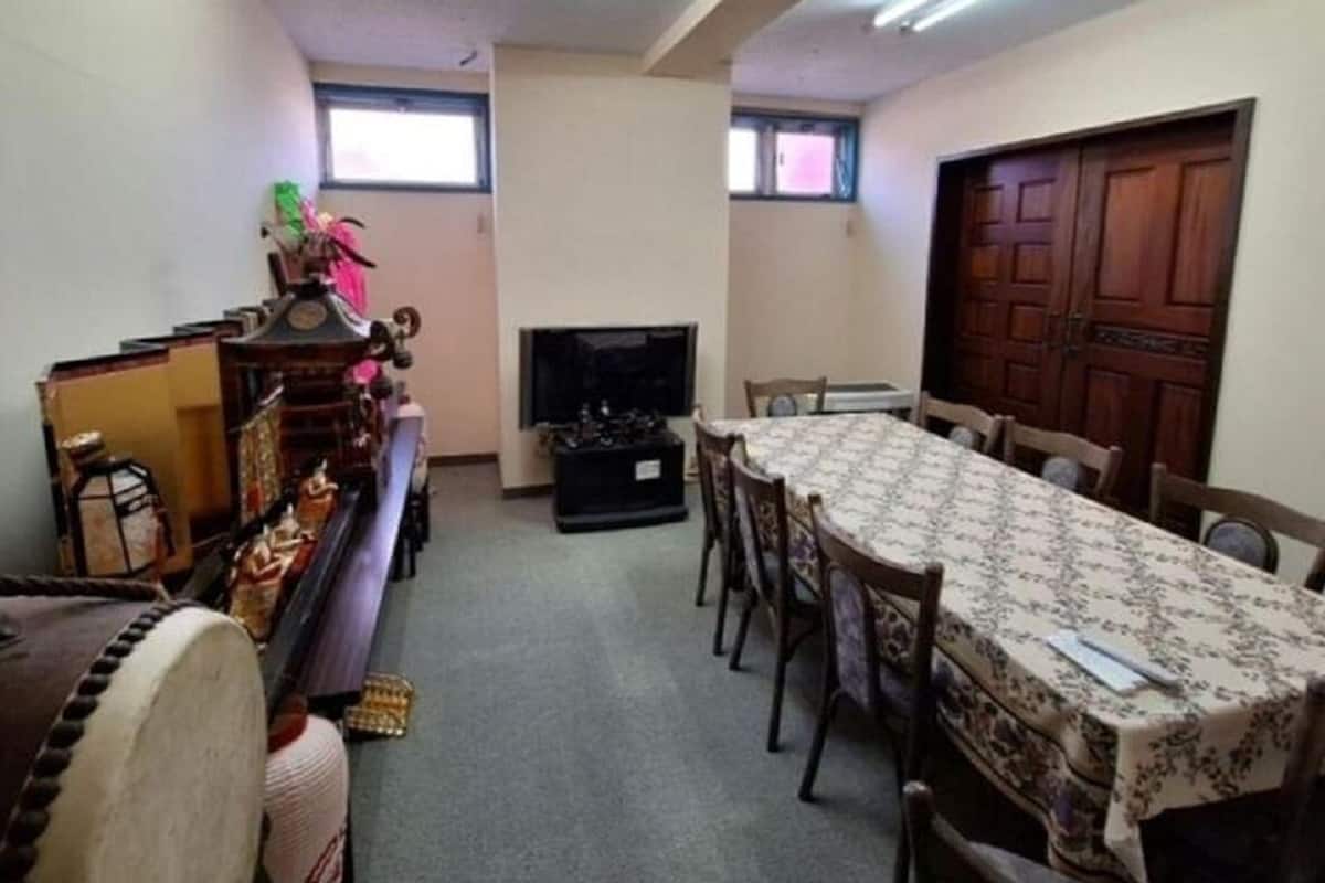Un espace repas comprenant une longue table, des chaises, un téléviseur et une cheminée.