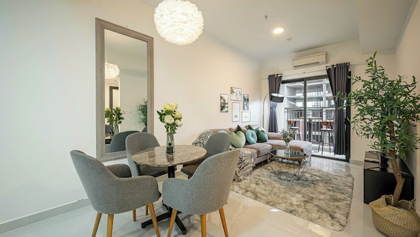Una sala moderna con comedor, un espejo grande y vistas al balcón exterior.