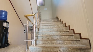 A staircase with metal railings and a water dispenser on the left.
