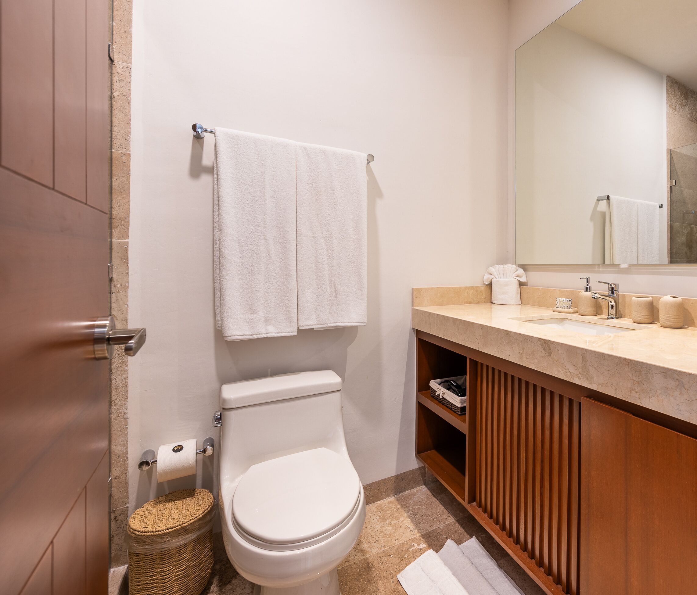 A modern bathroom with a toilet, sink, and mirror.