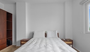 A bedroom with a bed, two nightstands, a wooden wardrobe, and a window. - Risco 603: 1BR Downtown Bucerias w Rooftop Pool (Bucerías)