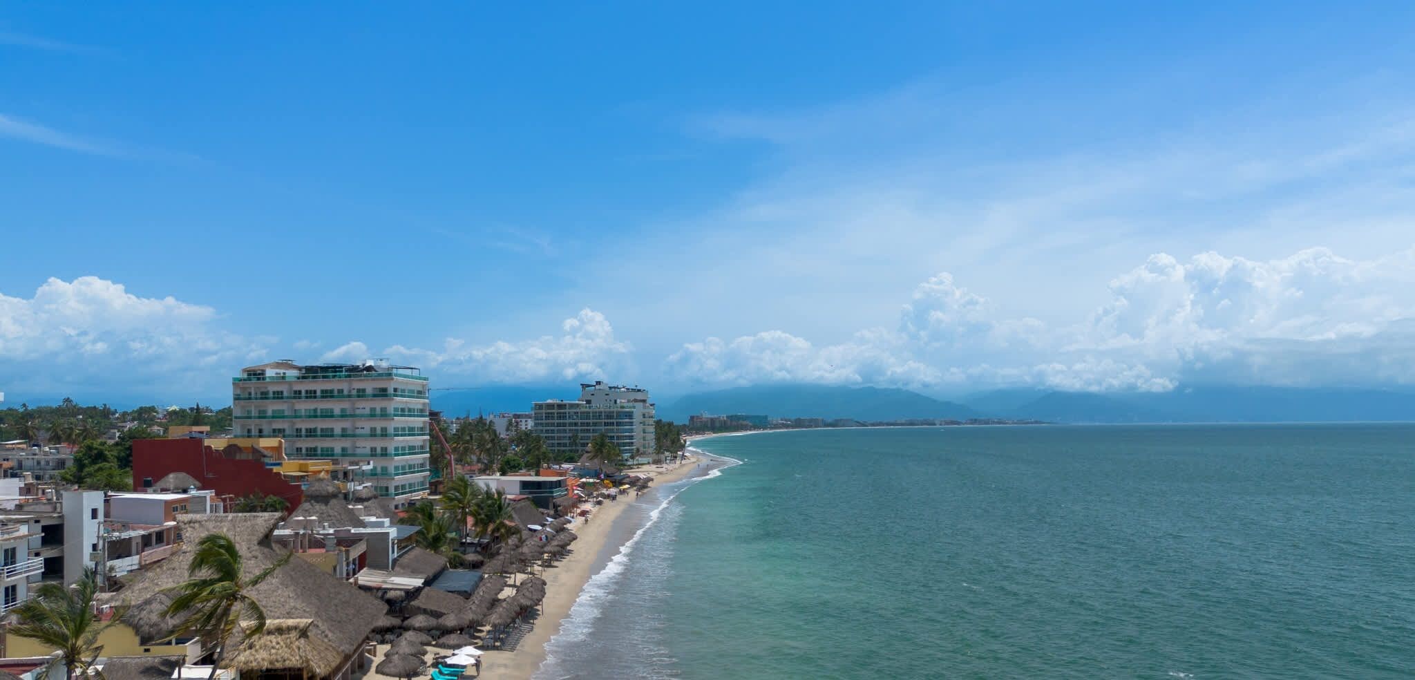 A coastal cityscape with buildings, a beach, and the ocean.