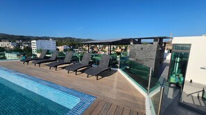A rooftop pool area with lounge chairs and a glass-enclosed bar. - Risco 603: 1BR Downtown Bucerias w Rooftop Pool (Bucerías)