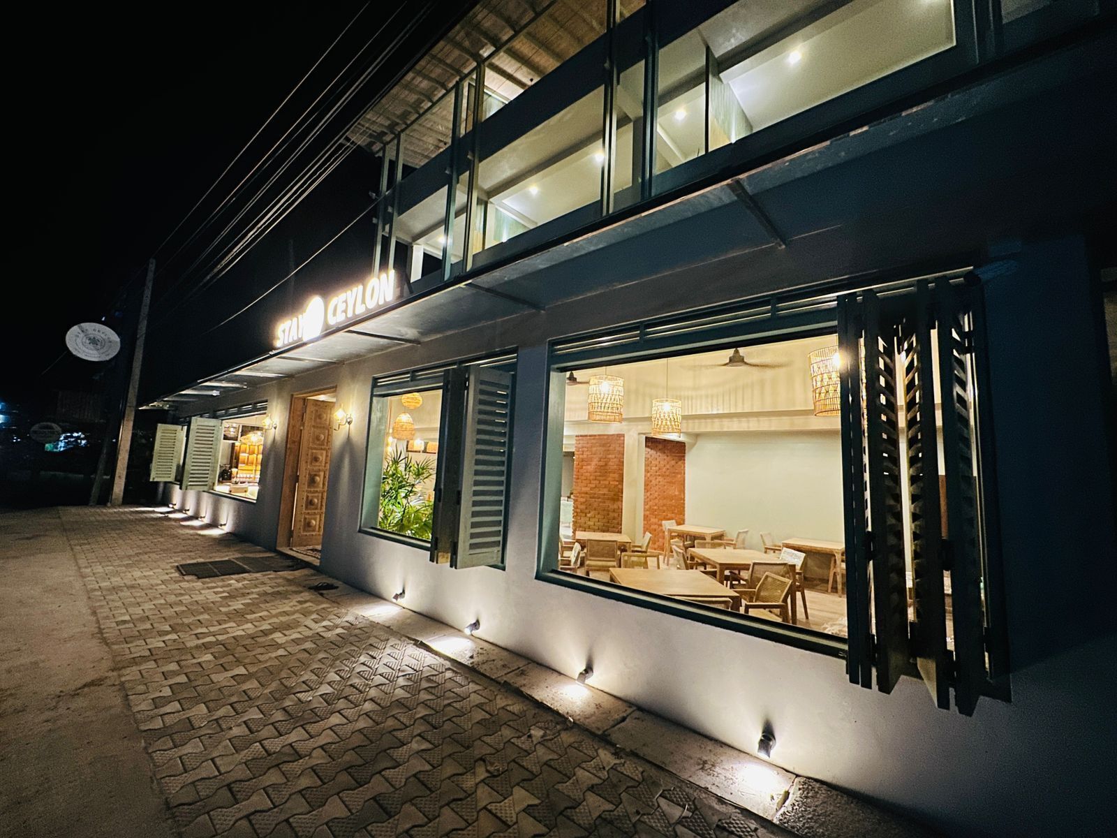 Un edifici modern amb un restaurant anomenat "Ceylon" de nit.