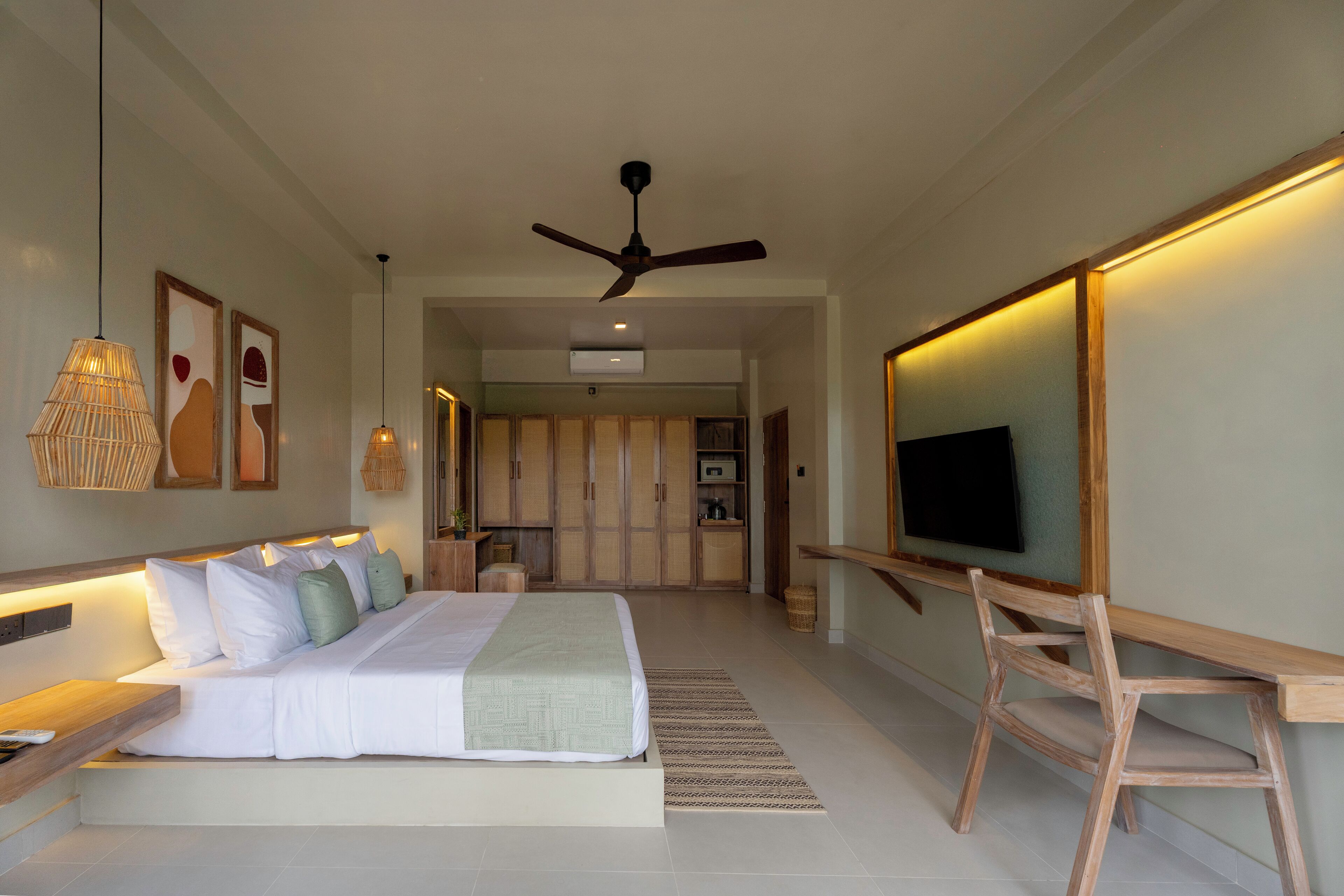 A modern bedroom with a bed, bedside tables, a TV, and a ceiling fan.