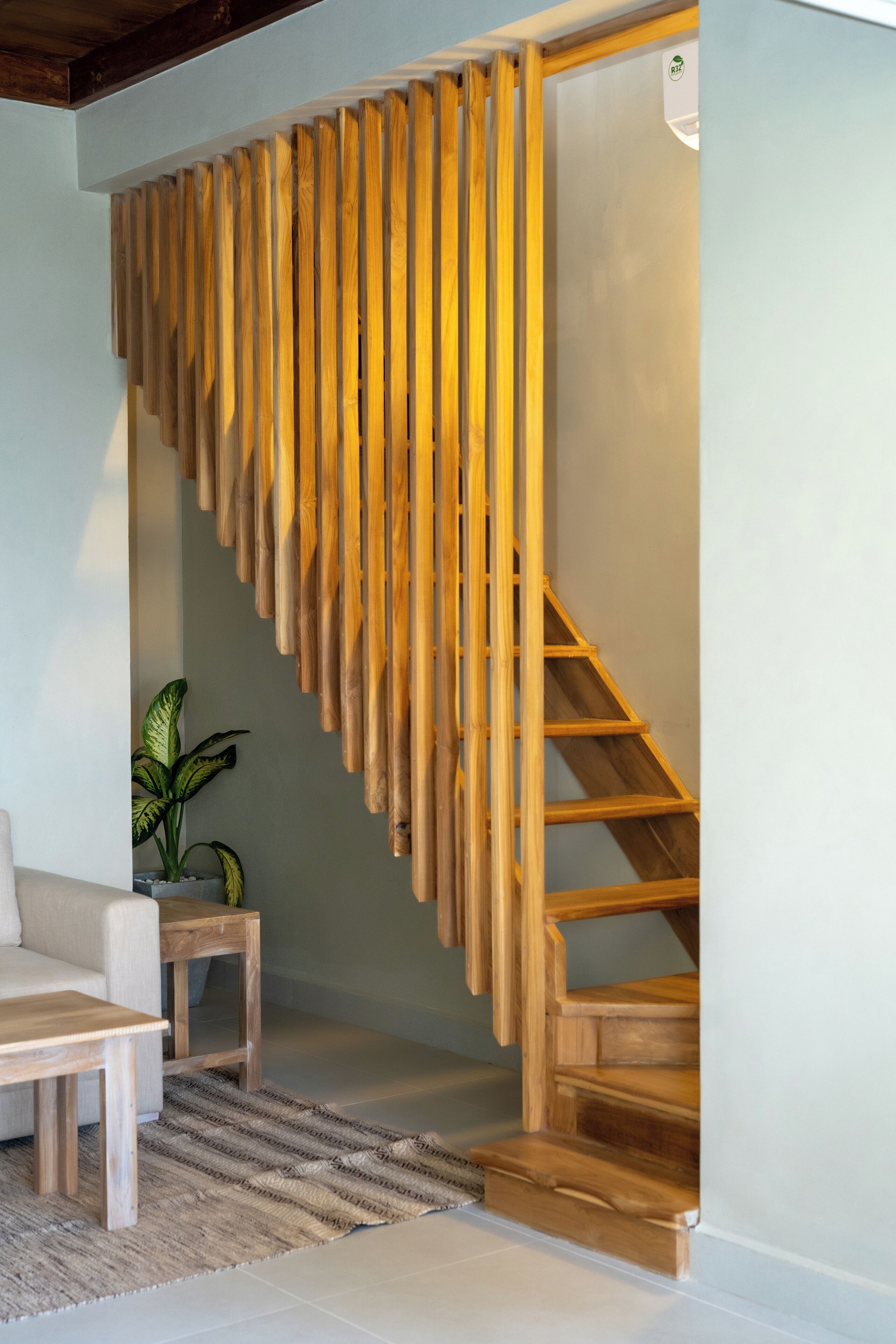 A staircase with wooden steps and a handrail made of vertical wooden slats.