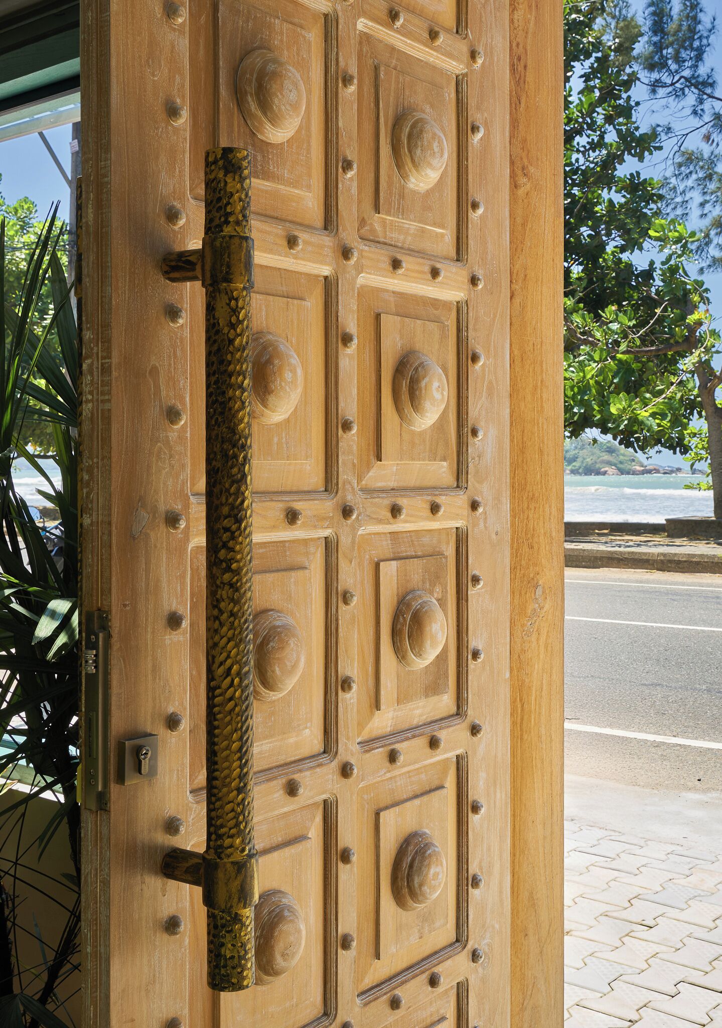 A wooden door with a textured handle and a keyhole.