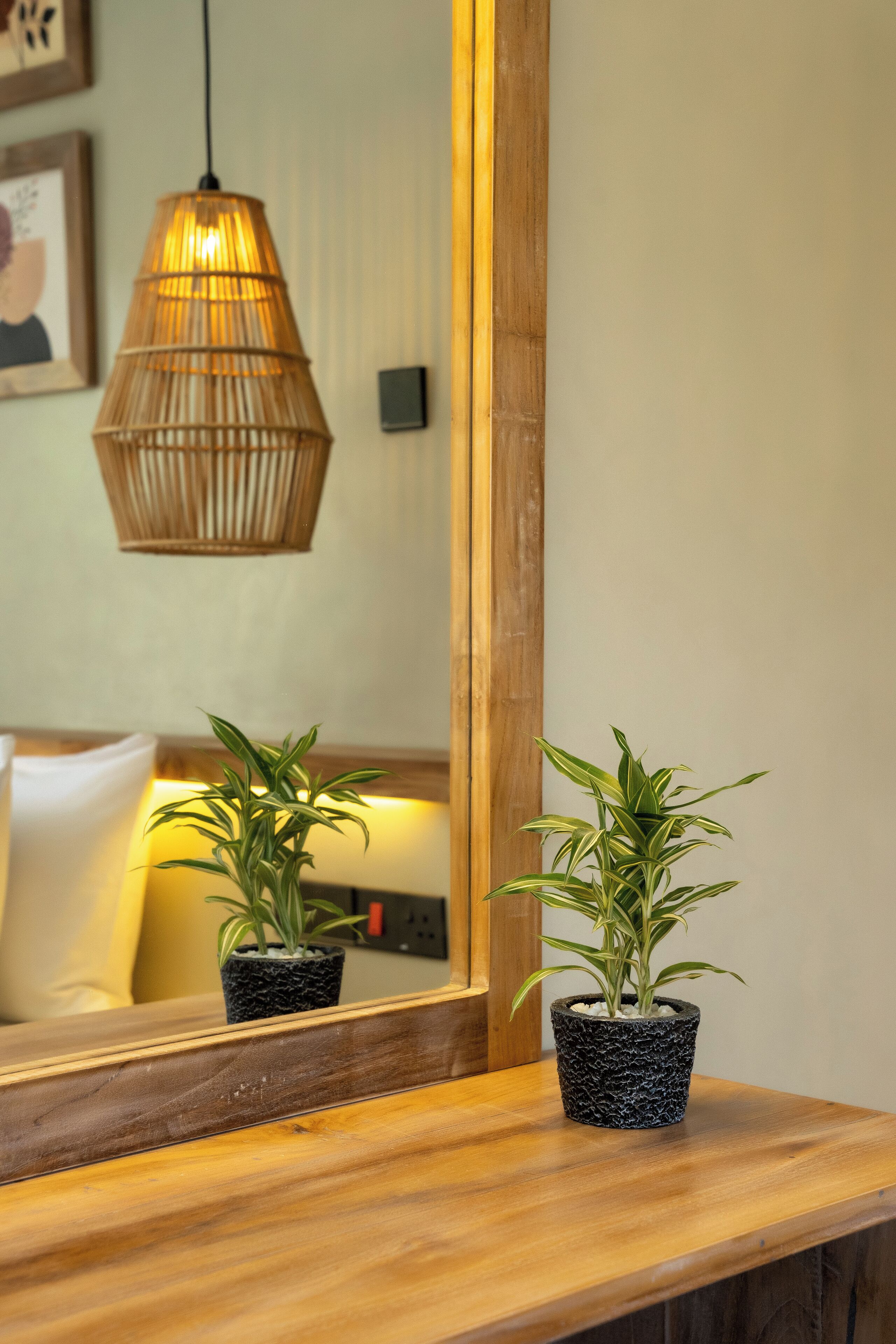 Una barra de madera con dos plantas en macetas y una lámpara colgante.