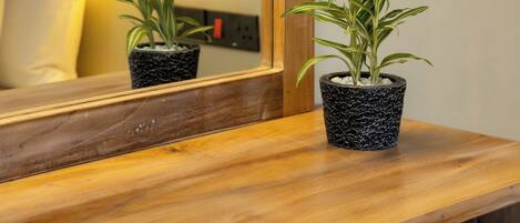 Una barra de madera con dos plantas en macetas y una lámpara colgante.