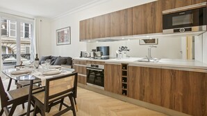 Una cocina moderna con muebles de madera, un horno Bosch y un comedor con una mesa preparada para cuatro.