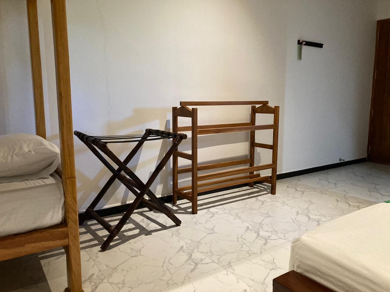 A room with a bed, a wooden bench, and a small table.