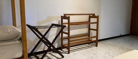 A room with a bed, a wooden bench, and a small table.