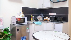 A compact kitchen with a microwave, stove, and cabinets.