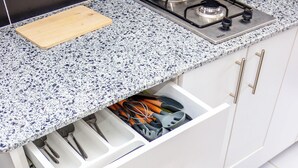 A kitchen with a granite countertop, white cabinets, and a gas stove. - Landmoor Studio Jkia Airport Way (Nairobi)