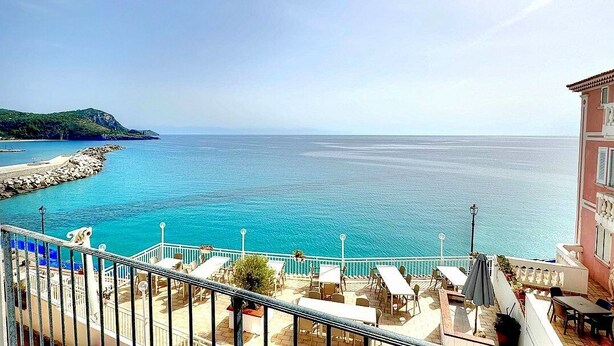 Une terrasse en bord de mer avec des places assises extérieures et une vue sur la mer.