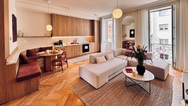 A modern living room with a sofa, coffee table, and dining area. - Luxury Apartment - 2 bedrooms (Nice)