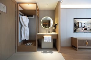 A modern hotel bathroom with a walk-in shower, a vanity with a mirror, and a television mounted on the wall. - Beijing Tang Fu Lama Temple Drum Tower Nan Luo Gu Xiang Dong Zhi Men Hotel (Beijing)