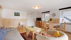 Una habitación acogedora con cama, una mesa de comedor, sillas, televisor y ventana con vistas.
