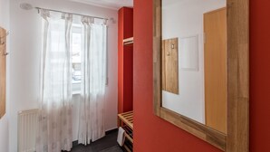 A room with a window, a wooden bench, a radiator, and a mirror on the wall. - Apartment 'Ferienwohnung Tannenblick 3-4' with Mountain View, Balcony and Wi-Fi (Oberhof)