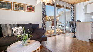 Ein modernes Wohnzimmer mit einer Couch, einem Couchtisch und einem Essbereich mit Tisch und Stühlen.