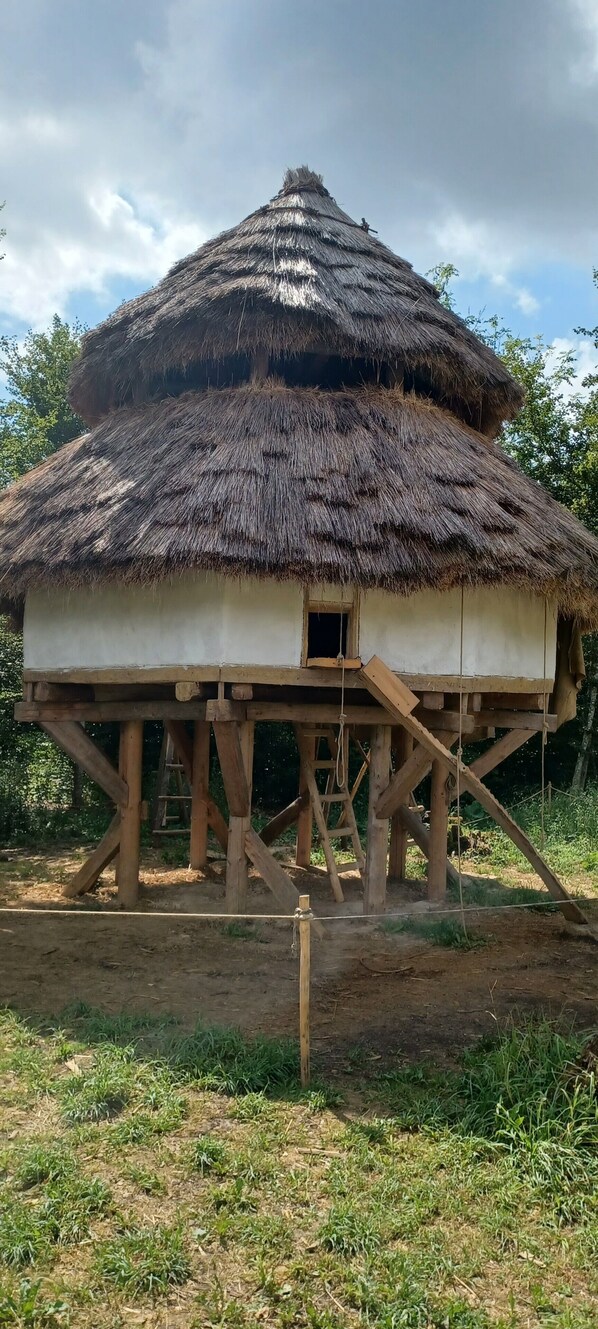 A thatched-roof structure with a simple, elevated wooden platform.