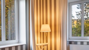 A room with a window, a lamp, and a chair. - Apartment '21' with Mountain View, Shared Terrace and Wi-Fi (Masserberg)