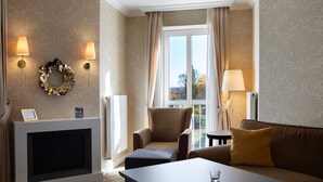 A hotel room with a fireplace, a sofa, a table, and two lamps. - Apartment '21' with Mountain View, Shared Terrace and Wi-Fi (Masserberg)