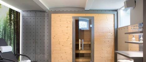Un spa moderno con sauna, paredes de paneles de madera, una puerta de vidrio y piso a cuadros.