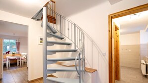 A spiral staircase with metal railings and wooden steps, leading to an upper floor. - Apartment 'Haus Am See - Zur Blauen Tür' with Lake View, Private Terrace and Wi-Fi (Templin)