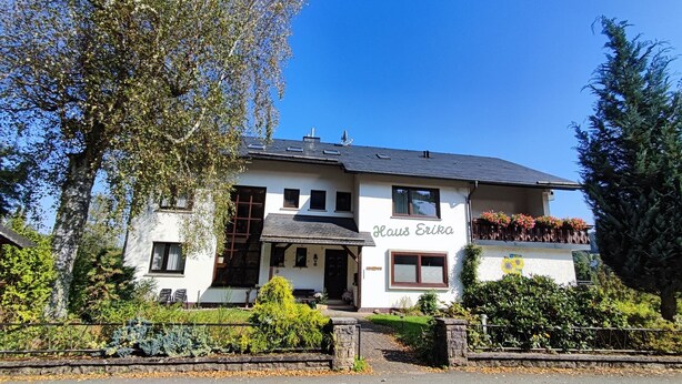 A two-story building with a sign 'Haus Erika' on the side.