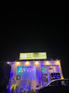 Um edifício com uma placa que diz "Tithill Home Stay & Cloud Kitchen A.C. & Air Cooled Rooms".