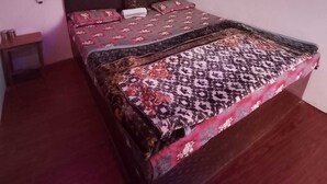 Une chambre à coucher avec un lit, une table de chevet et un luminaire au plafond.