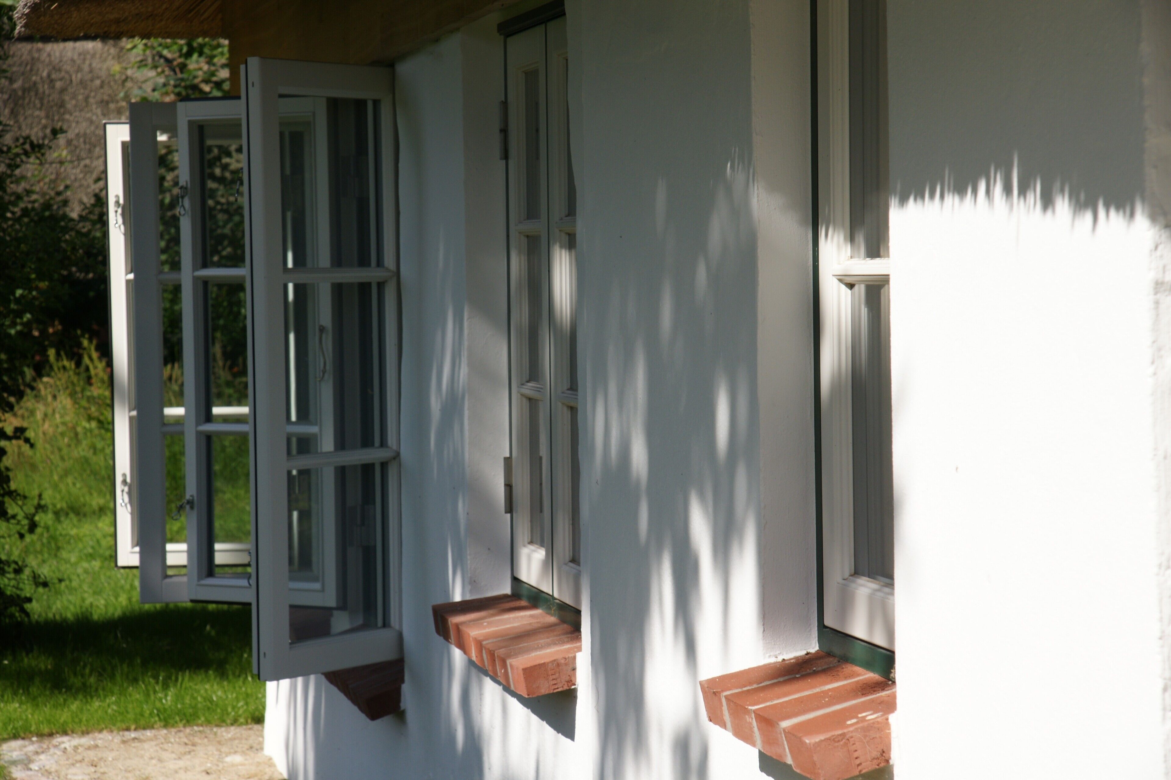 A white building with a partially open door and windows.