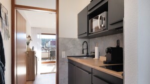 Une cuisine moderne équipée d’un four à micro-ondes, d’un évier et d’un lave-vaisselle.